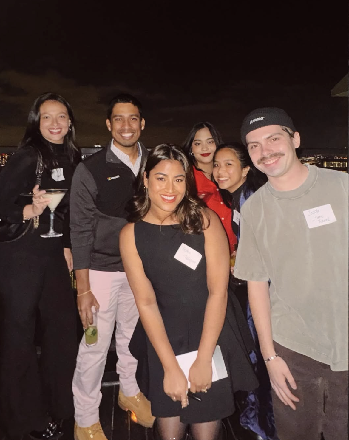 Design Lounge members on a rooftop balcony at night